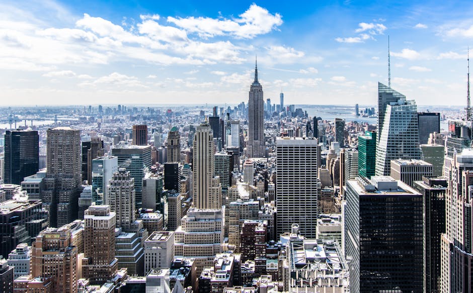 A stunning aerial view of New York City's skyline featuring the iconic Empire State Building under a bright blue sky