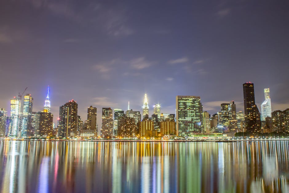 A breathtaking view of the New York City skyline illuminated at night, reflecting in the river