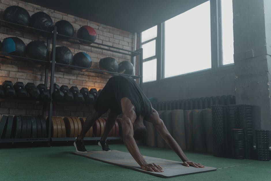 Man performing fitness workout on yoga mat in gym. Focus on strength and body posture.
